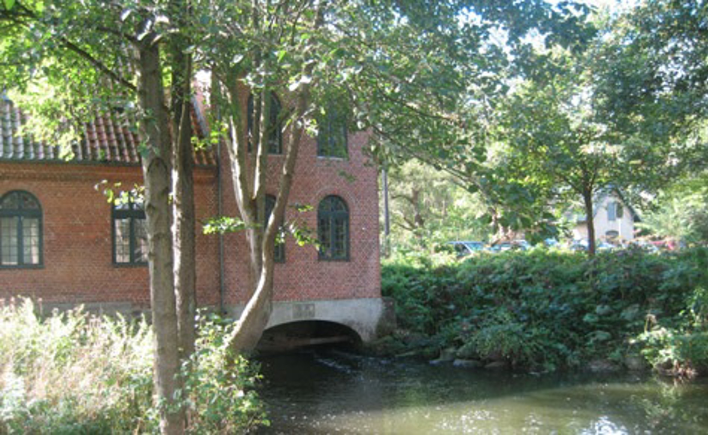 Fuglevad Mølle ved åens gennemløb under bygningen.